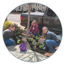Three people planting flowers in downtown Logan